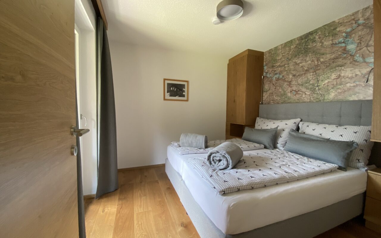Schlafzimmer mit Boxspring-Bett im Alpenhome Apartment