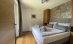 Schlafzimmer mit Boxspring-Bett im Alpenhome Apartment