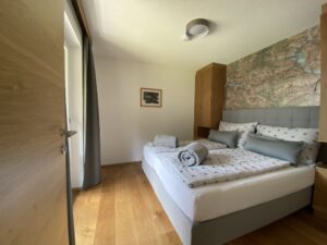 Schlafzimmer mit Boxspring-Bett im Alpenhome Apartment 5